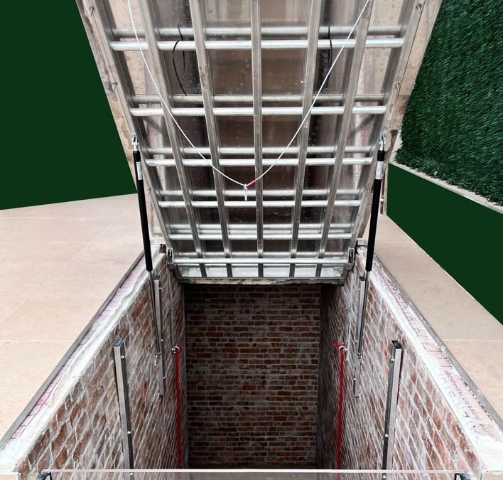 Escalera de acceso a sótano con portón abatible